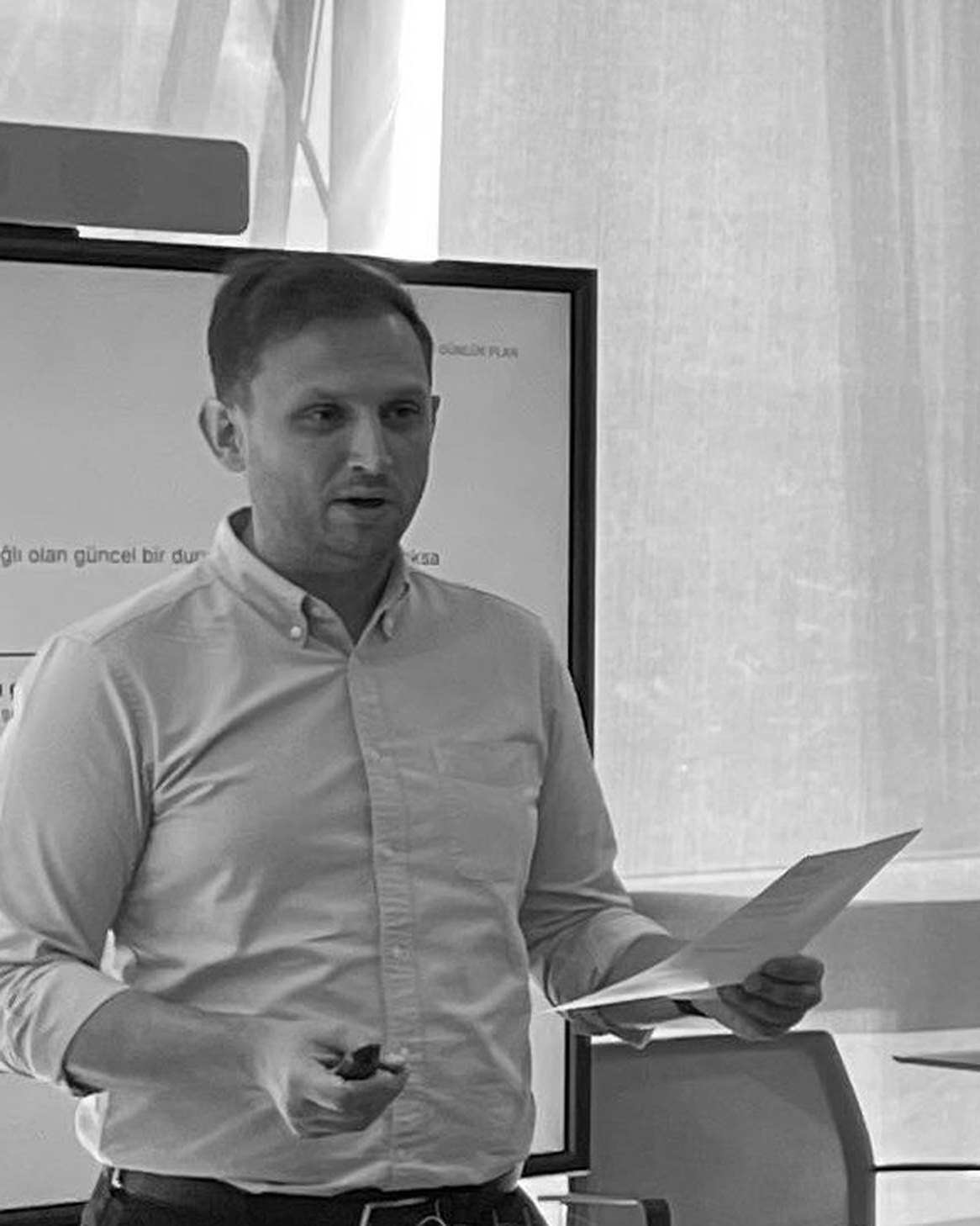 Tolga Temtek speaking in front of a screen during a training session